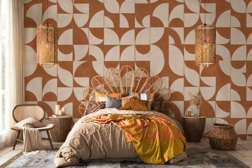 Geometric-patterned wallpaper in brown and beige tones features bold shapes and repeating lines, creating a modern, earthy visual focal point for the room. The design highlights neutral colors and strong geometry, making the wall standout in the cozy bedroom setting.
