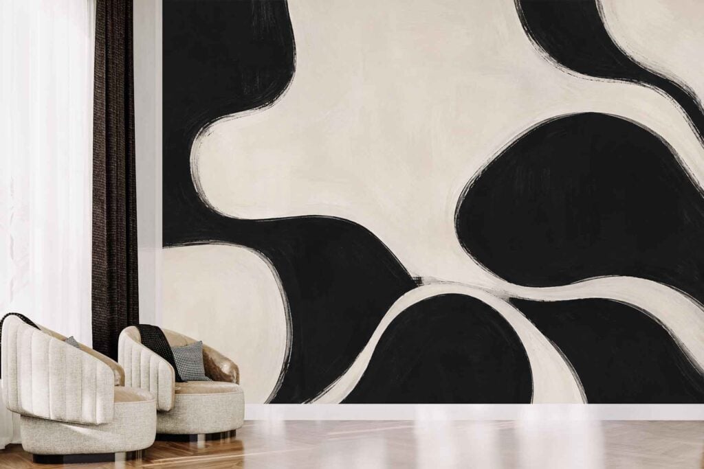 Abstract black and white mural wallpaper features bold, organic, flowing shapes. The design contrasts sharply with the neutral surroundings, making the abstract pattern a focal point in the room.