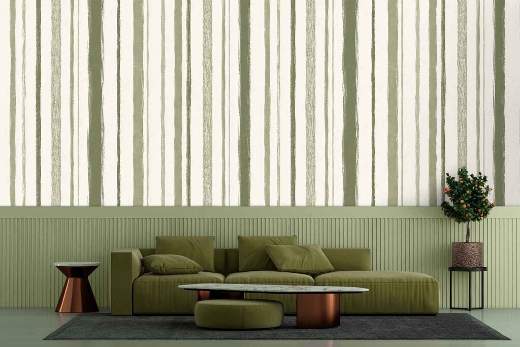 Striped wallpaper featuring alternating green and neutral tones sits above the green wainscoted wall in this living room, adding a subtle pattern and texture to the space.