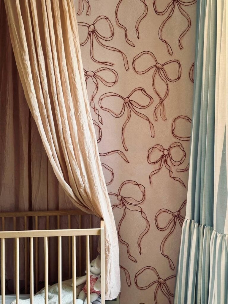 The wallpaper features large, pink bow designs on the wall.