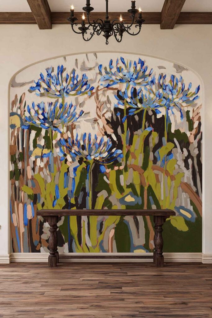 Wallpaper mural features large blue and purple flowers with green stems and leaves on an arched wall.