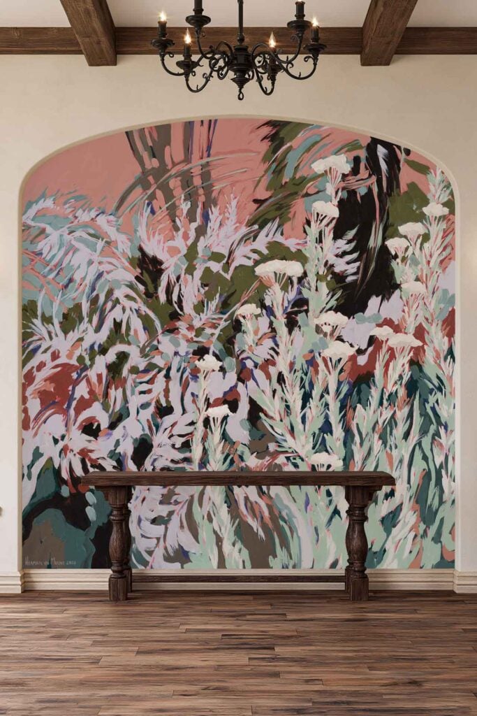 Colorful abstract mural wallpaper with overlapping plant shapes in pink, green, and white tones on an arched wall. Features bold leaf silhouettes and organic patterns blending these colors together.