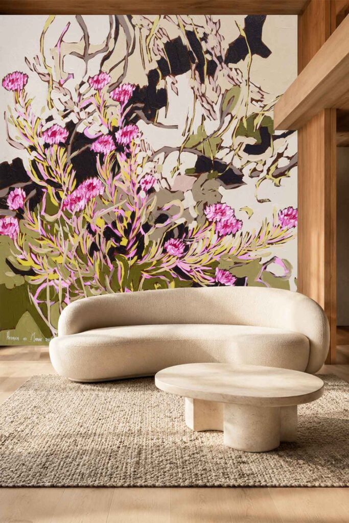 A large wall mural features an abstract floral design with pink flowers, green accents, and beige tones. The wallpaper’s bold artistic style stands out in the room, defined by its mix of vibrant pinks and subtle greens on a neutral beige background.