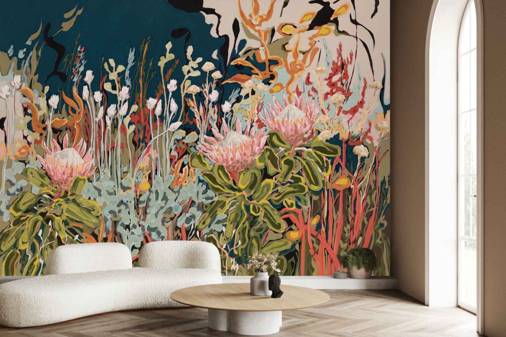 Colorful botanical mural wallpaper with abstract flowers and lush greenery in bold hues, featuring overlapping shapes in pink, green, yellow, and blue tones. The vibrant mural showcases large floral patterns and leafy accents as the main focal point of the room’s decor.