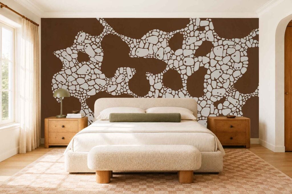 A brown accent wall with an abstract white patterned wallpaper serves as the bedroom’s focal point. The wallpaper features bold, modern white shapes and lines set against a rich brown background.