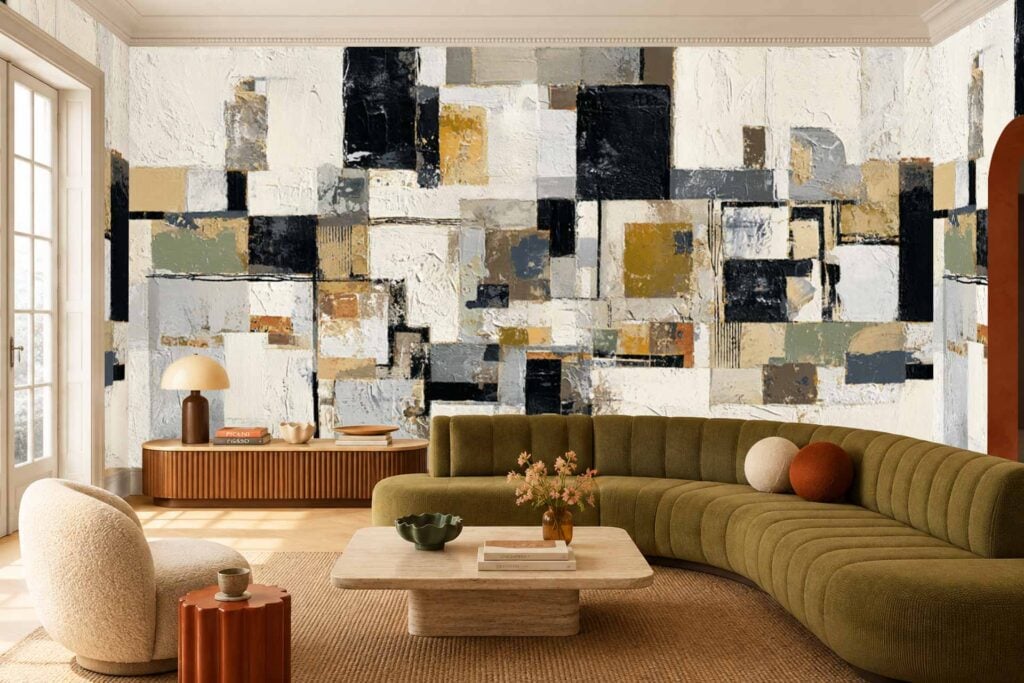 Large abstract geometric mural featuring bold blocks of white, black, gray, and gold on the living room’s back wall; striking modern wallpaper design with sharp lines and contrasting colors.